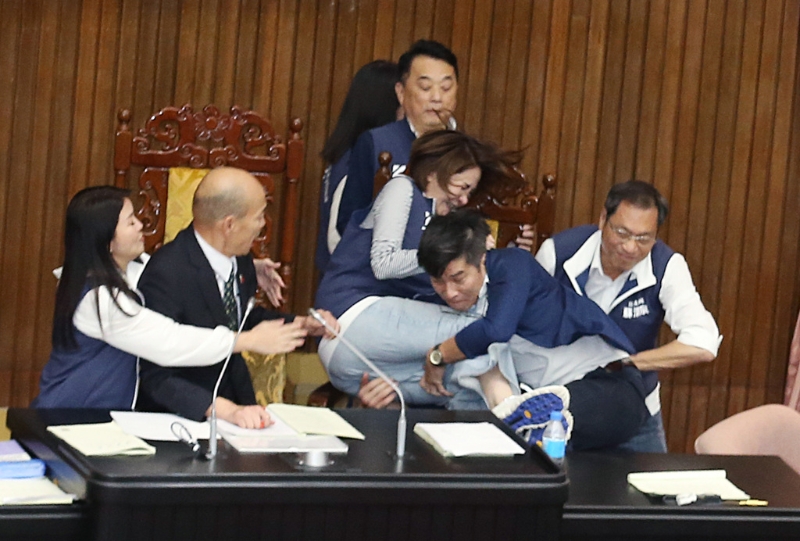 “立法院”17日院會表決大戰一觸即發，民進黨“立委”鐘佳濱（右二）翻上桌沖向主席臺，擋在院長韓國瑜（左二）前的國民黨“立委”陳菁徽（中右）前被鐘一把抱住，2人雙雙跌落桌下。 （姚志平攝）