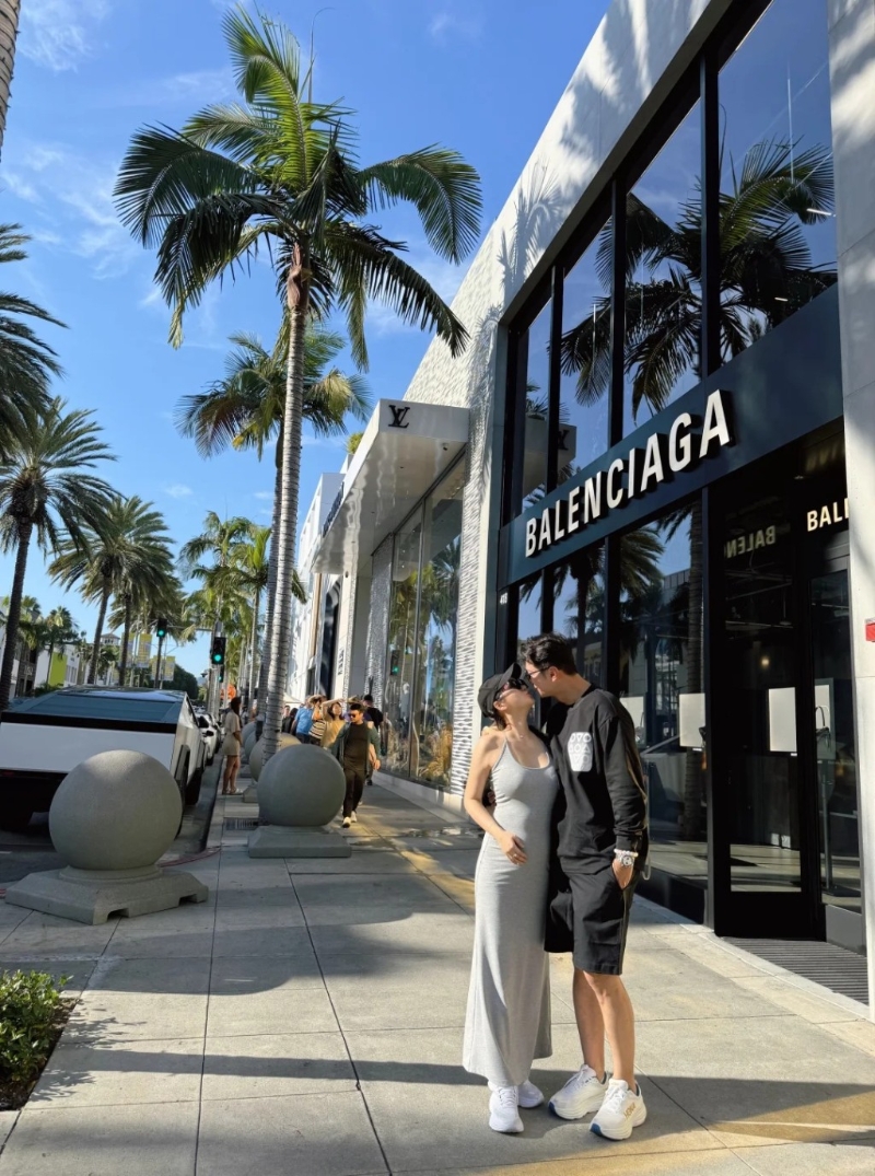 高鈞賢與女友在街頭甜蜜咀嘴，他女友皮膚非常白皙且身材高?。她身穿灰色貼身吊帶連身裙配白波鞋，用了右手遮肚凸凸的肚子，中指更戴上疑似定婚戒指，孕味濃。