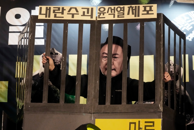 南韓首爾國會外要求尹錫悅下臺的群眾，11日晚間戴上尹錫悅面具置身標明「逮捕叛亂首腦尹錫悅」的牢籠，藉此表達對于尹錫悅的強烈不滿情緒。（美聯社）