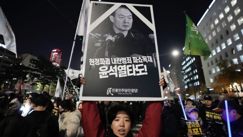 示威民眾高舉“推翻叛亂罪犯尹錫悅”的抗議海報。