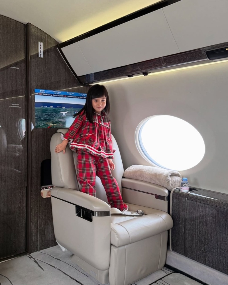 女兒在私人飛機上企上座椅。