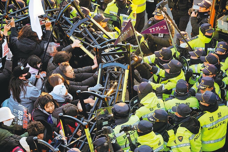 韓國公調處人員周五與總統警衛處經過5個多小時對峙，仍無法逮捕被彈劾的總統尹錫悅。圖為反尹的抗議民眾，在總統官邸附近與警察發生沖突。