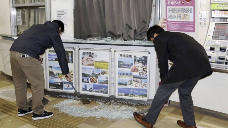 地震發生后，民眾清理地面碎玻璃。