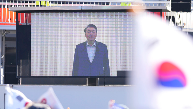 韓國總統尹錫悅15日上午被捕，不過從他被捕到到案接受訊問幾乎沒有畫面。圖為韓國總統官邸附近支持群眾觀看尹錫悅的影片聲明。