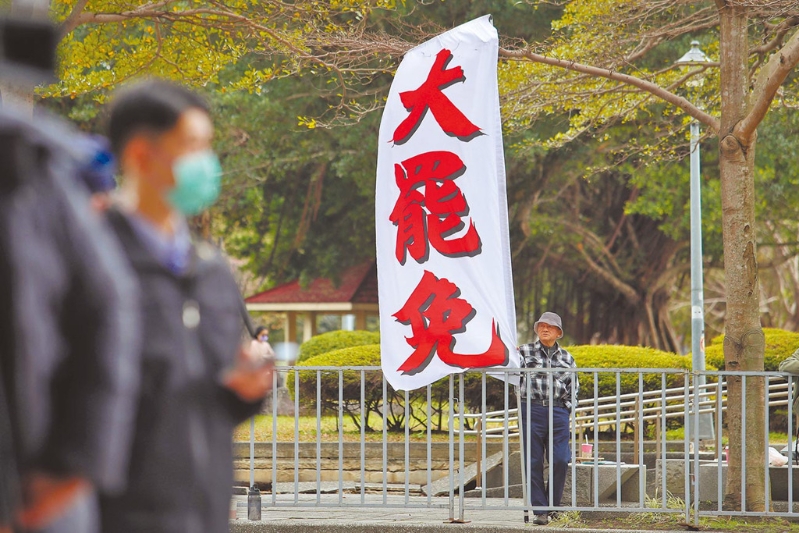 圖為民進黨2月5日召開會議，民眾在中央黨部樓下高舉旗幟，要求黨主席賴清德對大罷免表態。
