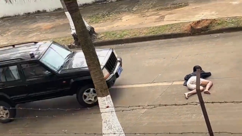 女替身演員躺在路中心，汽車駛近。