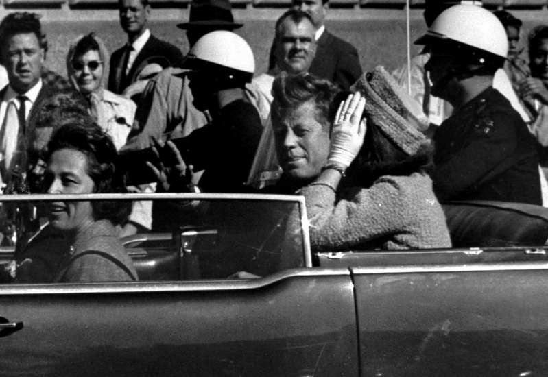 畫面為1963年11月22日，美國已故總統肯尼迪乘車行經達拉斯，向群眾揮手，一分鐘后他就遭到槍殺身亡。美聯社