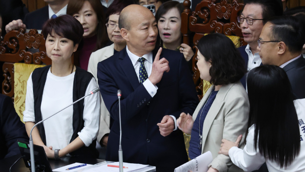 “立法院”25日院會開始，民進黨“立委”上到主席臺包圍院長韓國瑜（中）杯葛議事，并要求說明新黨副秘書長游智彬事件，韓宣布休息。