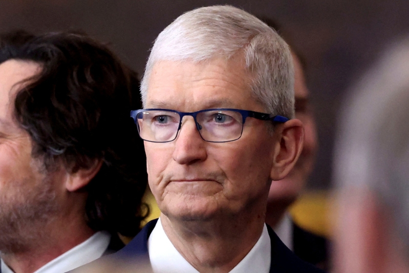 庫克在特朗普對中國關稅政策壓力下再次承諾將在美國建廠生產iPhone，但專家認為這項承諾仍是庫克的緩兵之計。 圖為庫克面色凝重地參加特朗普就職典禮。路透社.jpg