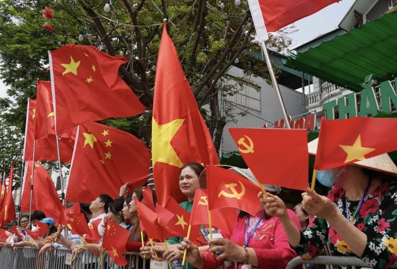 機場附近有民眾持中越國旗和中共黨旗歡迎習近平到訪。 新華社