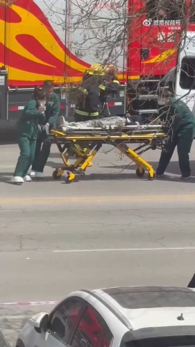 救護人員將傷者抬上救護車。
