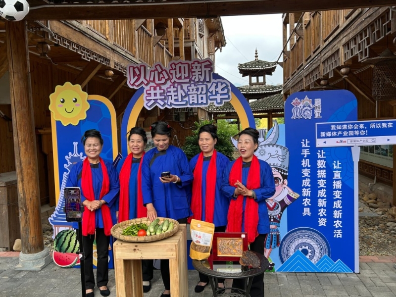 在新媒體產業園，一群穿著侗族服裝的中年婦女唱著侗歌直播帶貨。
