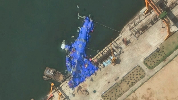 用藍色防水布覆蓋的受損驅逐艦衛星照