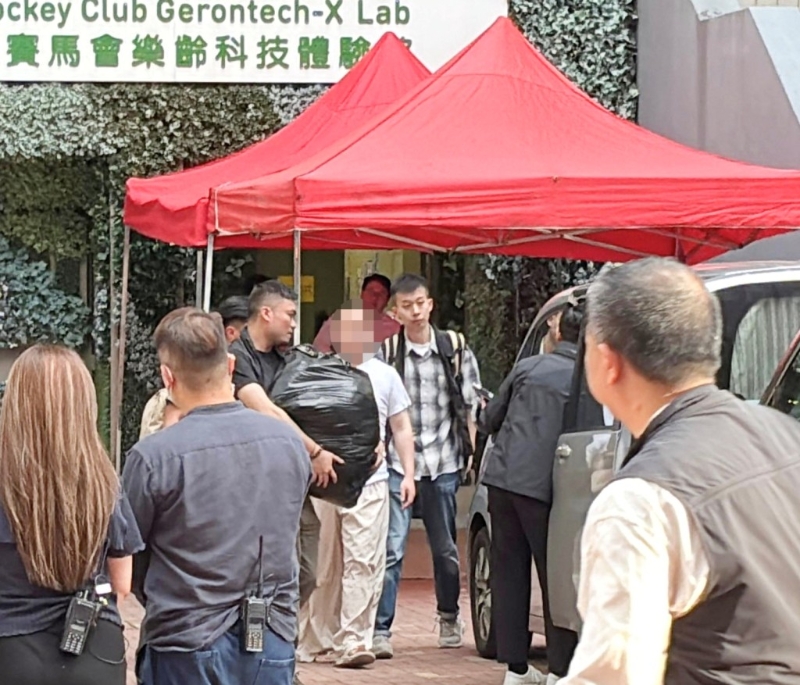 警方6月5日押解其中一名被捕人到宿舍搜證。資料圖片