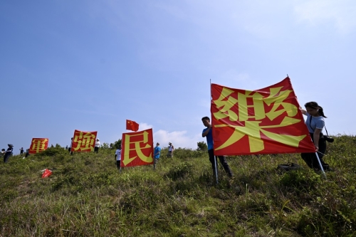 有市民于玉桂山頂上舉起自制的“軍強民樂”旗幟，表示是回應山東艦進港時甲板上的“國安家好”字句 。